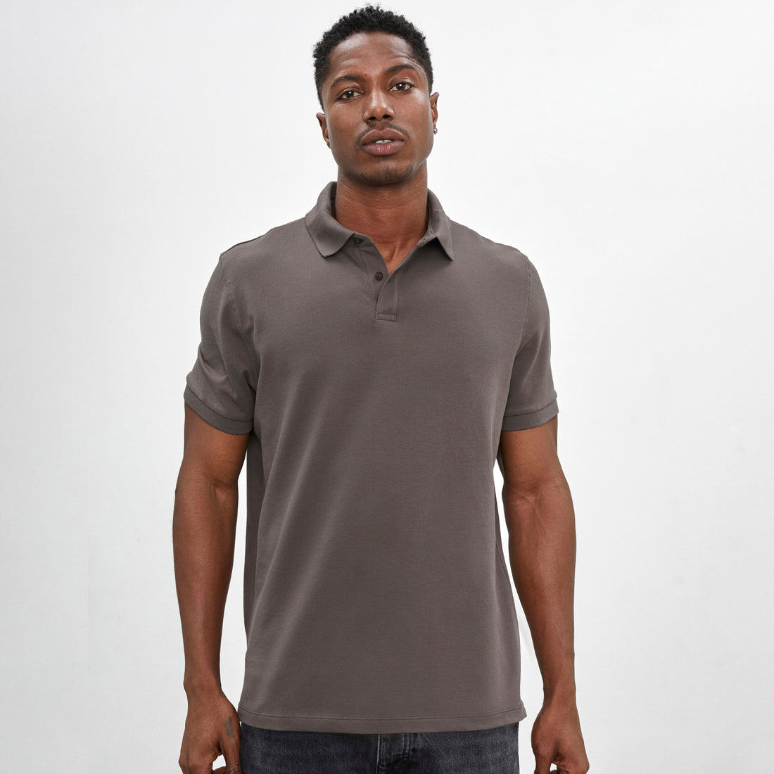 Polo con cuello en tejido piqué de color marrón tierra y manga corta de algodón Pima, vista frontal con modelo