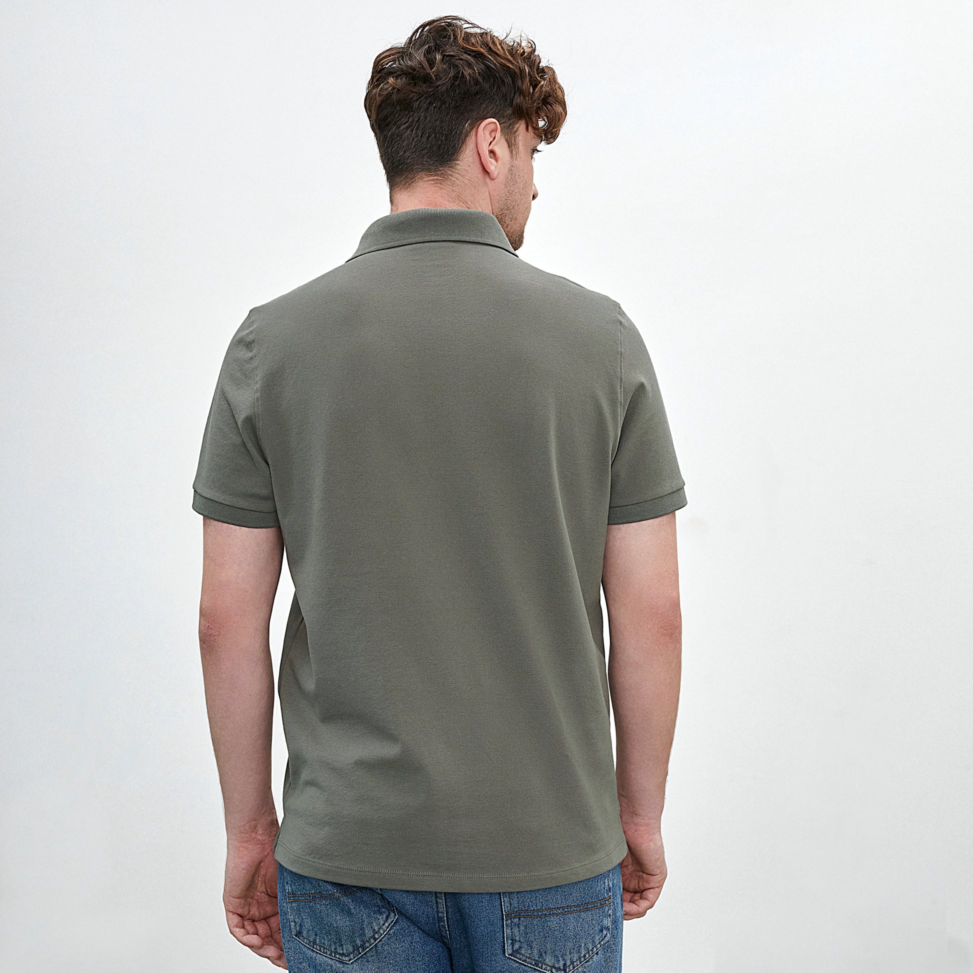 Polo con cuello en tejido piqué de color verde olivo y manga corta de algodón Pima, vista posterior con modelo